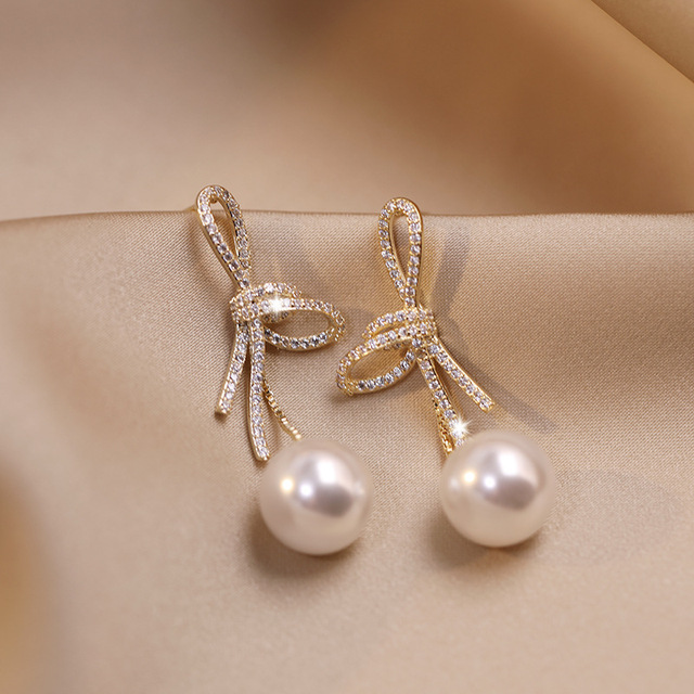 Gold Pearl Earrings with Dazzling Bow Design